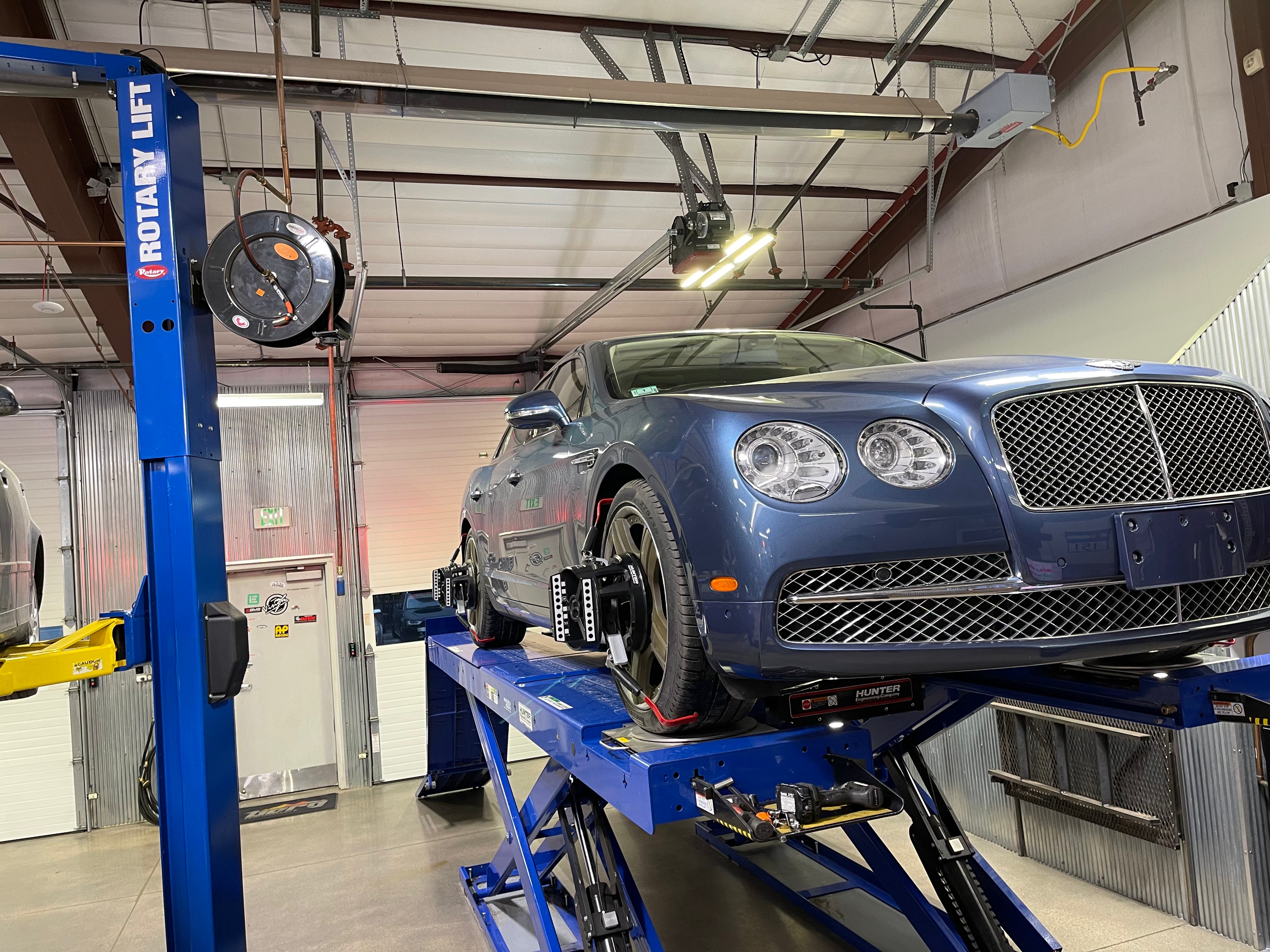 Bentley on a car lift in the shop for maintenance